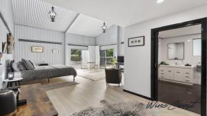 WillungaThe Cubby House by Wine Coast Holiday Rentals的带床、水槽和镜子的卧室
