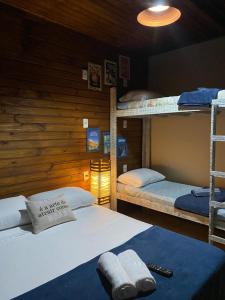 普腊亚罗萨Pousada Lua Nova Praia do Rosa的小屋内带两张双层床的客房