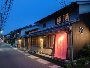 Machiya Hotel oyado baison في Mino: مبنى على جانب الشارع في الليل