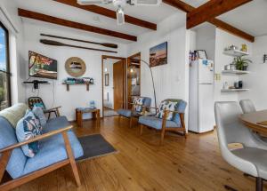 a living room with a blue couch and a refrigerator at Jetty View - Rosella Cabin in Nungurner
