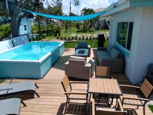 a deck with a pool and chairs and a table at Beach Oasis in Fort Myers Beach