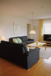 - un salon avec un canapé noir et une table basse dans l'établissement Ferienwohnung Wallner, à Prien am Chiemsee