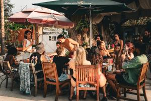 a group of people sitting at a table in a restaurant at Nopalero Hostel in Puerto Escondido +36 photos
