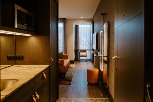 墨尔本The Motley Hotel Richmond, Tapestry Collection by Hilton的带水槽的厨房和客厅