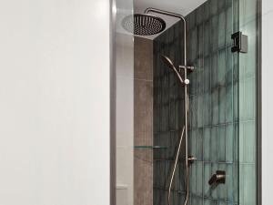 a shower in a bathroom with a glass wall at Hampshire Holiday Parks - Queenstown Lakeview in Queenstown +74 photos