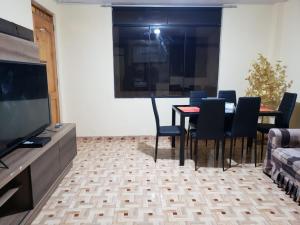 a dining room with a table and chairs and a television at Carosvi Home in Lima