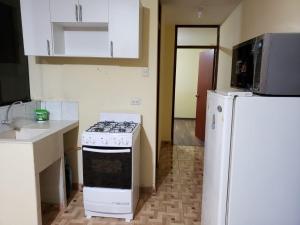 a kitchen with a stove and a refrigerator at Carosvi Home in Lima +14 photos