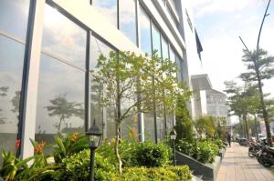 a building with glass windows and plants in front of it at Ina apartment - Nera garden Hue in Hue