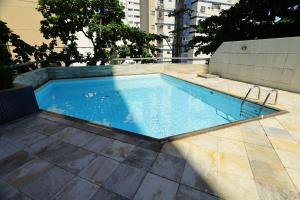 una piscina de agua azul en un suelo de baldosa en Conforto e localização privilegiada na Pituba, en Salvador