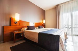 a hotel room with a bed and a window at Hotel Granollers in Granollers