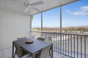 a dining room with a table and chairs and a balcony at South Seas Bayside Villa 4116 - Newly Renovated Marina View Condo in Captiva