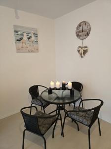 a dining room table with candles and a clock on the wall at New 2 Bedroom, 2 Bathroom Apartment in Pisak in Pisak