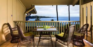 哈纳Hana Kai Maui - #205 Mokuhano, upper floor studio的阳台上的桌子和椅子，可欣赏海景