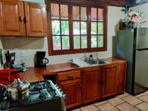 una cocina con estufa y refrigerador en Calypso Cabaña, en Cahuita