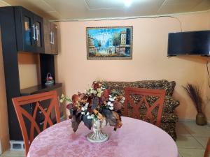 un vaso di fiori su un tavolo con un divano di Apartamentos y Hostal RUDON #4 a Puerto Cortés