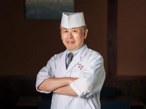 由布市Yufuin Rakuyu的戴着头巾的头戴头巾的男人,手臂交叉