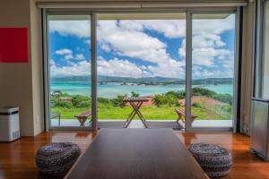 a dining room with a table and a large window at 20C Ryukyu in Nakijin