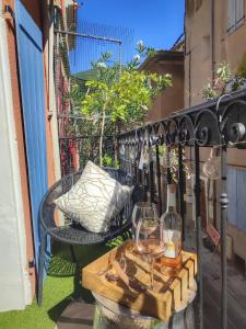 a balcony with a table and a glass of wine at L'appartement de la rivière qui chante in Nyons