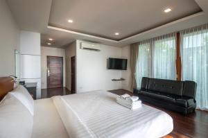 a bedroom with a large bed and a black couch at PP Mountain Beach Resort in Phi Phi Islands