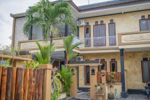 una casa con delle palme davanti di Twin OLA a Tabanan