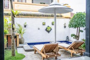 un patio con due sedie e un ombrellone di Twin OLA a Tabanan Altre 4 foto