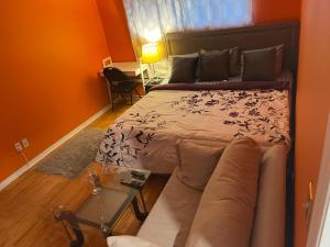 una camera da letto con un letto, un divano e un tavolo di Travelers Home a Oshawa Altre 9 foto
