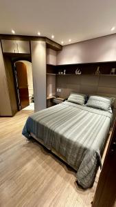 a bedroom with a large bed in a room at Flat Cosmopolitan Praia no Gonzaga com Varanda - Estacionamento Incluso in Santos +16 photos