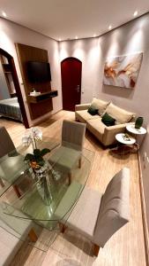 a living room with a couch and a glass table at Flat Cosmopolitan Praia no Gonzaga com Varanda - Estacionamento Incluso in Santos