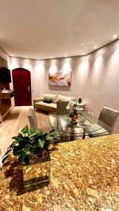 a living room with a couch and a glass table at Flat Cosmopolitan Praia no Gonzaga com Varanda - Estacionamento Incluso in Santos