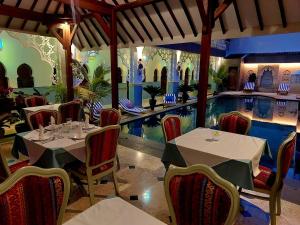 a restaurant with a swimming pool and tables and chairs at Blue Garden Boutique Hotel in Jepara