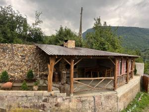 a wooden building with a roof on a stone wall at Ghazaryan's Home Guesthouse Lori in Debed