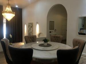 a dining room with a table and chairs and a chandelier at Calma Villa Jalan Sultanah in Alor Setar