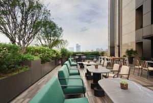 a row of tables and chairs on the roof of a building at Kimpton Da An Taipei- an IHG Hotel in Taipei