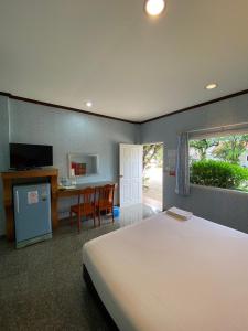 a bedroom with a bed and a kitchen and a desk at Soda Resort in Kamphaeng Phet