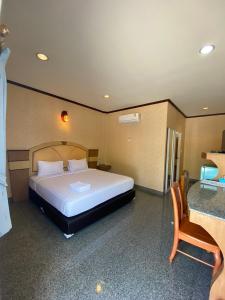 a bedroom with a large bed in a room with a table at Soda Resort in Kamphaeng Phet