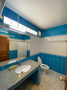 a blue and white bathroom with a sink and a toilet at Soda Resort in Kamphaeng Phet