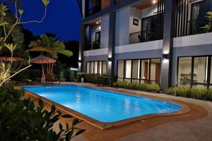 a swimming pool in front of a building at night at Friendly Hotel Krabi in Ao Nam Mao