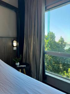 a bedroom with a bed and a large window at Apartamento Sunset House Porchat in São Vicente