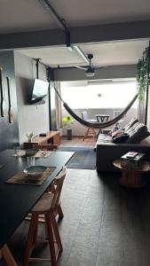 a living room with a couch and a hammock at Apartamento Sunset House Porchat in São Vicente