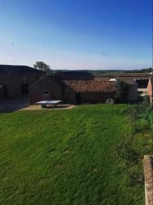 a grassy yard with a building and a picnic table at Countrylife Cottage for Groups- BBQ , firepit, free parking in Lincoln