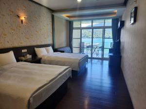 a hotel room with two beds and a balcony at Sun Fog Hotel in Yuchi