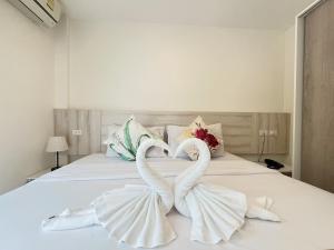 two towel swans sitting on top of a bed at Mystays Phuket in Phuket