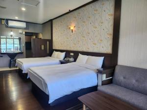 a hotel room with two beds and a couch at Sun Fog Hotel in Yuchi