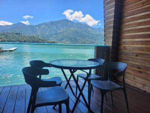 a table and chairs on a deck with a view of the water at Sun Fog Hotel in Yuchi