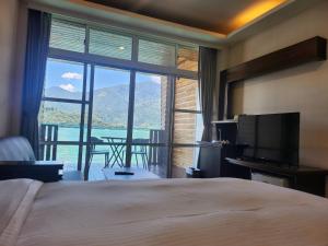 a hotel room with a bed and a large window at Sun Fog Hotel in Yuchi
