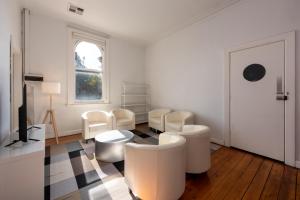Camera bianca con sedie bianche e finestra di Private Unit in Heritage Building in Fitzroy North a Melbourne