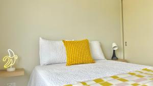 a bedroom with a yellow pillow on a bed at Oasis boutique condominios in Juarez in Ciudad Juárez