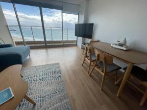 sala de estar con escritorio y vistas al océano en Oceanic 28 On The Beach, en Forster