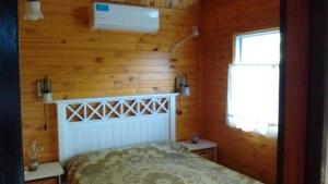 a bedroom with a bed in a wooden wall at Cabañas Pa ke mas in Punta Indio