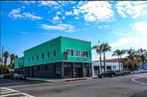 a green building on the side of a street at Plaza Hotel Gardena in Gardena